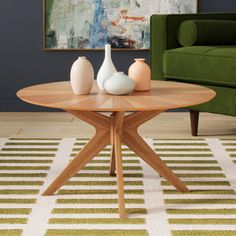 a table with vases on it in front of a green couch