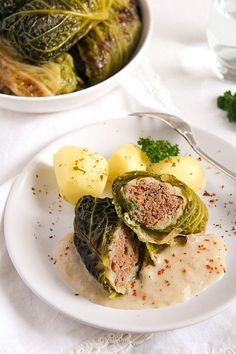 a plate with some food on it next to a bowl full of potatoes and greens