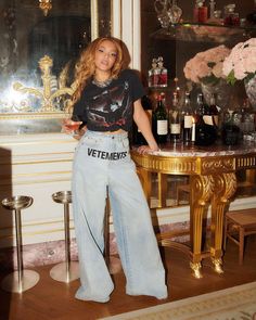 a woman standing next to a table with bottles on it