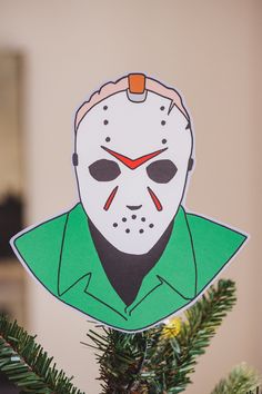 a christmas tree with a paper mask hanging from it