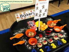 there is a black tray with cookies and other items on it that are in the shape of numbers