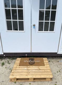 a wooden pallet sitting in front of a white door