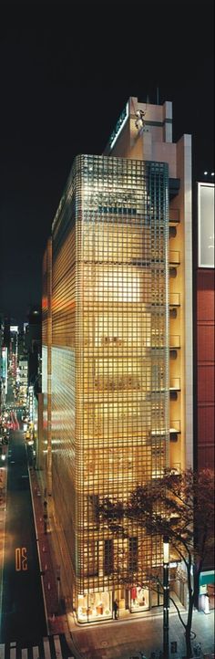 a tall building sitting on the side of a road next to a traffic light at night