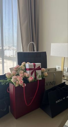 flowers and gifts are on the table next to each other in front of a window