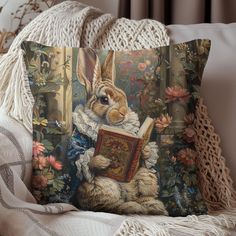 a pillow with a painting of a rabbit reading a book on it's back