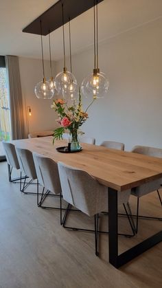 a dining room table with six chairs and a vase filled with flowers on top of it