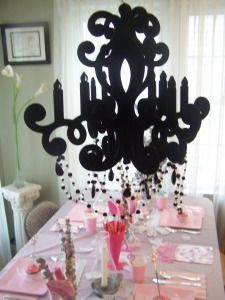 the table is set with pink and black decorations