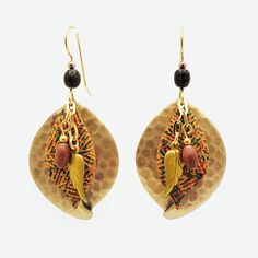 Elevate your jewelry collection with this pair of exquisite fall earrings featuring layered leaf shapesone with a soft hammered texture and another with a fall raku. The metal layers create a dramatic backdrop for a leaf charm and rice bead chain drop on surgical steel with 18k gold overlay ear wires. These layered metal earrings make a memorable gift or a perfect self-purchase. | Silver Forest metal drop earrings feature layered leaf designs with bead accents. | Surgical steel ear hooks with 18 Bohemian Leaf-shaped Brass Jewelry, Bohemian Brass Leaf Jewelry, Handmade Dangle Jewelry For Fall, Handmade Leaf-shaped Metal Jewelry, Handmade Metal Leaf Jewelry, Bohemian Leaf-shaped Metal Jewelry, Bohemian Leaf-shaped Metal Earrings, Autumn Tones, Metal Drop