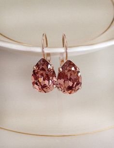 Gorgeous, simple pair of earrings featuring 14x10mm pear crystals in a light burgundy color. Rose gold plated settings, as shown, or silver or gold plated. Please choose metal from the drop down menu at check out. Earrings are a little over 1 inch long, 10mm wide. Thanks for stopping by. Make Jewelry For Beginners, Jewelry For Beginners, Mauve Jewelry, Burgundy Earrings, Light Burgundy, Crystal Teardrop Earrings, Pretty Jewelry Necklaces, Make Jewelry, Colorful Jewelry