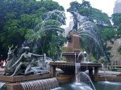 a fountain with statues and water jets in the park