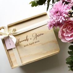 a wooden box with pink flowers and a ribbon tied around it