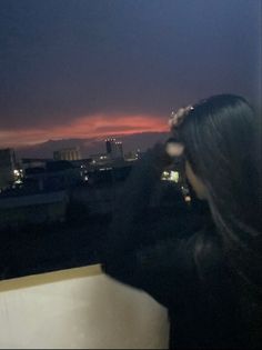 a woman standing on top of a roof looking at the sky