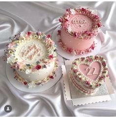 three heart shaped cakes on top of each other with the word love spelled in frosting