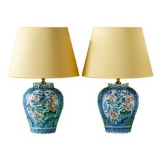 two blue and white vases with lamps on top of each one, both decorated in floral designs