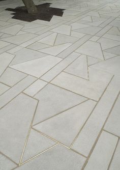 a concrete floor with gold lines and a tree in the background