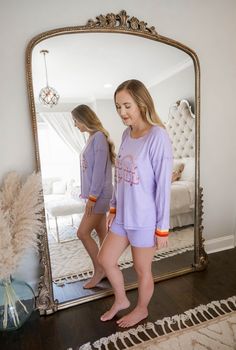 This is a long sleeve purple shirt with matching shorts set with the phrase “one day at a time” printed on it. The shorts feature an elasticized waist. The model is wearing a size medium.