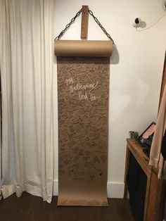 a cardboard board with writing on it hanging from a chain