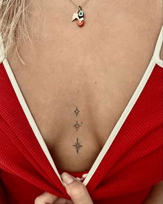 the back of a woman's neck with a small star tattoo on her left side