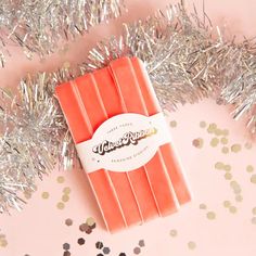 On a pink and silver tinsel background is a peach colored spool of velvet ribbon. Unique Packaging, Peachy Pink, Velvet Ribbon, Pink Ribbon, Gift Giving, Home Gifts, Ribbon, Velvet, Gift Wrapping