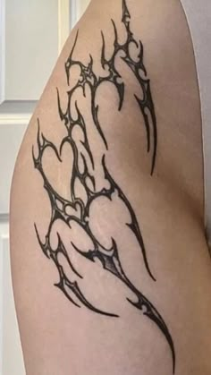 a tattoo on the back of a woman's thigh with black lines and hearts