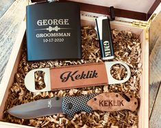 an open box containing a knife, lighter and personalized flask bottle openers