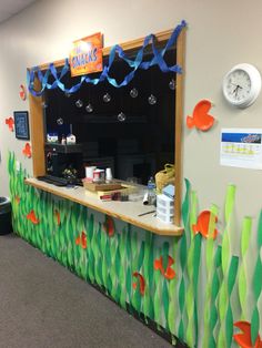 a fish themed wall in an office with blue streamers hanging from it's ceiling