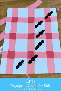 an insect craft made out of pink and white paper with black ants on it