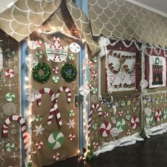 christmas decorations are displayed on the wall in front of an open door and decorated with lights