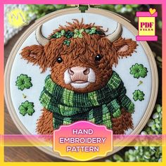 a cross stitch pattern with a brown cow wearing a green sweater and shamrocks on it