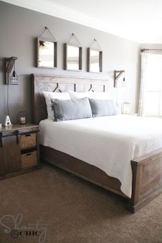 a bedroom with a bed, nightstands and pictures hanging on the wall above it