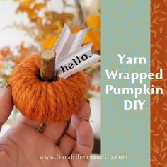 yarn wrapped pumpkin in the shape of a needle with name tag on it and text overlay that says yarn wrapped pumpkin diy