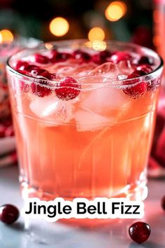 a close up of a drink in a glass on a table with cranberries