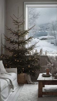 a living room with a christmas tree in front of a large window and a couch