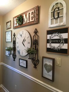 the wall is decorated with several different clocks and frames, including one for each family member