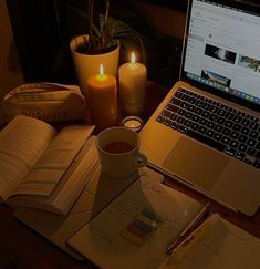 an open laptop computer sitting on top of a desk next to a cup of coffee