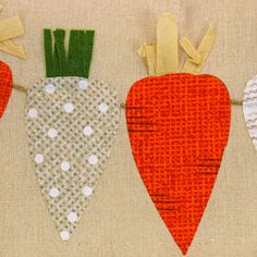 three carrots are hanging on a clothesline with white polka dots and green stems