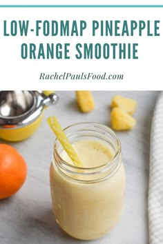 an orange smoothie in a mason jar with a straw and two oranges on the side