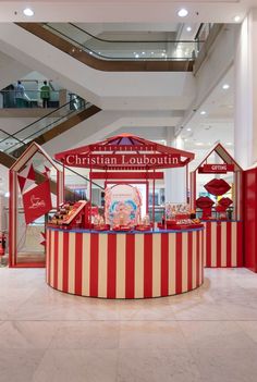 a carousel in the middle of a mall with red and white stripes on it's sides