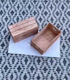 two wooden boxes sitting on top of a piece of paper