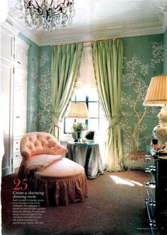 a living room with green walls and curtains on the window sill, pink chair in front of an open window