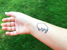 a person's arm with a small tattoo of a sheep on the left wrist