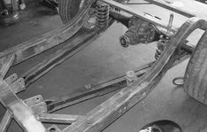 the rear end of a car being worked on by an engineer in a shop or repair shop