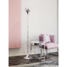 a living room with a pink couch and chrome floor lamp