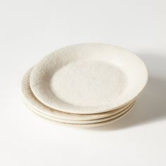 four white plates stacked on top of each other in front of a white background,