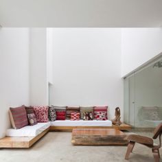 a living room filled with lots of furniture next to a white wall and flooring