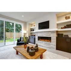 a living room with a fireplace and large sliding glass doors leading to the back yard