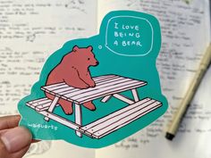 a sticker with a bear sitting on a picnic table saying i love being a bear