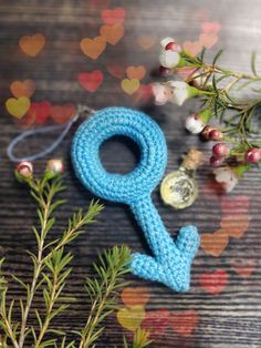 a blue crocheted keychain sitting on top of a wooden table next to berries