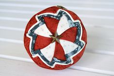 an ornament made to look like a red and white ball with a star on it