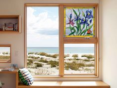 a bedroom with a desk and two windows overlooking the beach